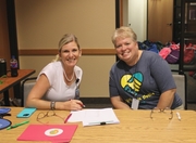 Service Providers, Tami Miller and Kristy Hanks, greeting families as they pick up their backpacks.